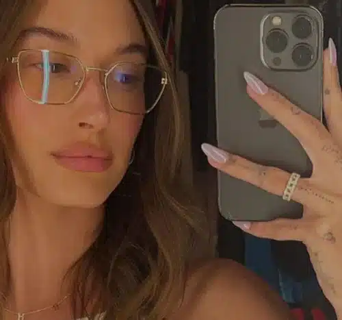 Hailey Bieber exibindo unhas com design minimalista e efeito Donut glaceado.