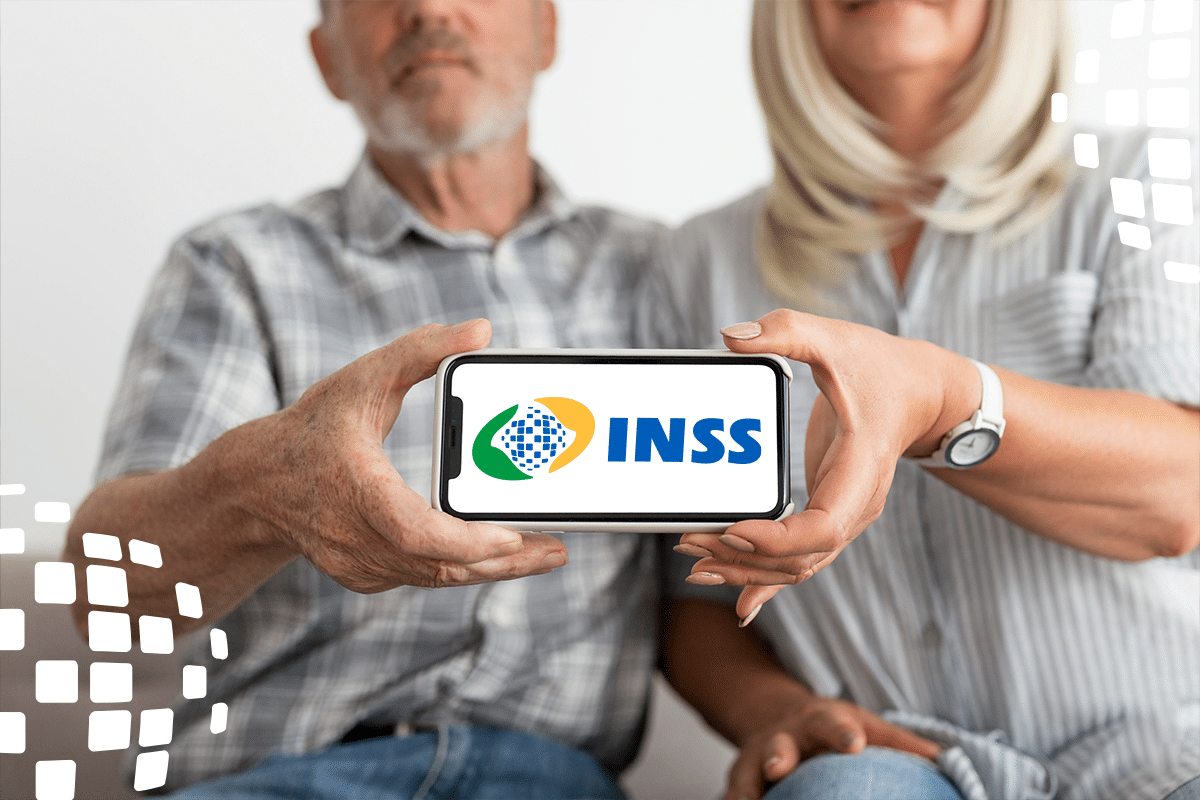 Casal de idosos segurando um celular com o logo do INSS visível na tela.