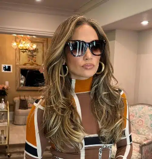 Jennifer Lopez exibindo um elegante corte butterfly cut com cabelos longos e volumosos.