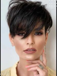 Mulher com corte pixie escuro e franja longa desfiada cobrindo parte do rosto.