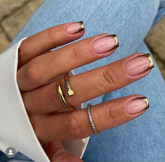 Unhas com francesinha metalizada em dourado nas pontas, sobre base nude natural.