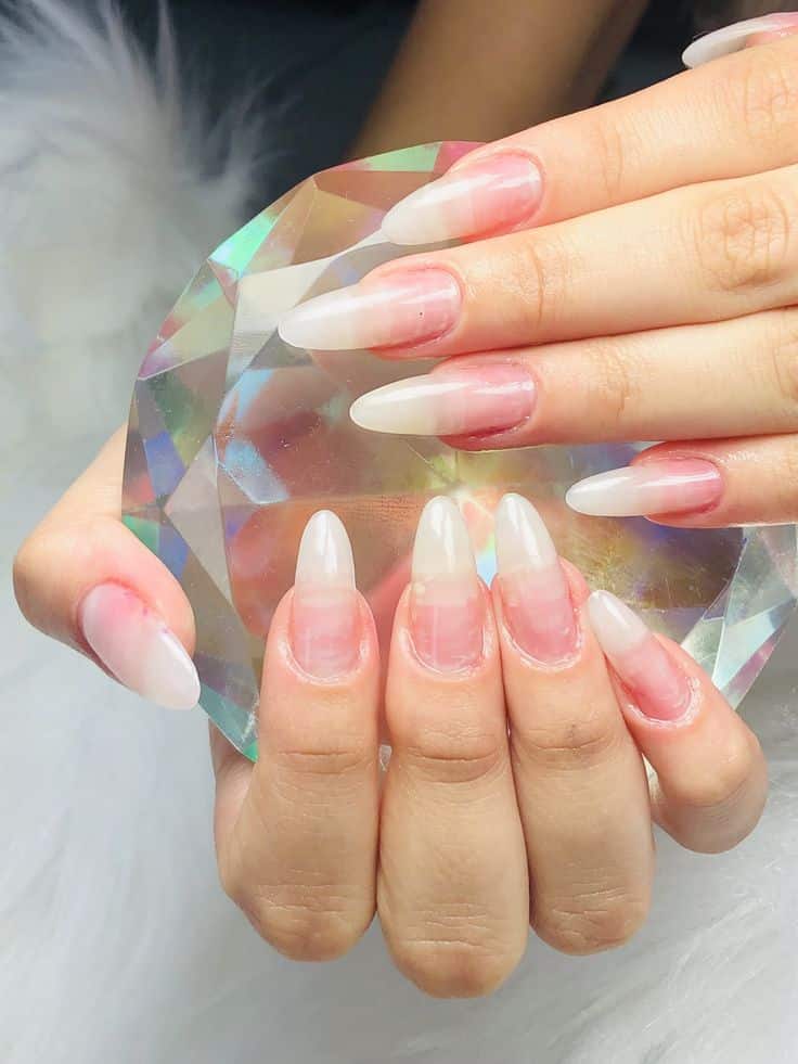 Unhas em gel no formato amendoado, com acabamento translúcido e efeito natural, tendência delicada para mulheres acima de 50 anos