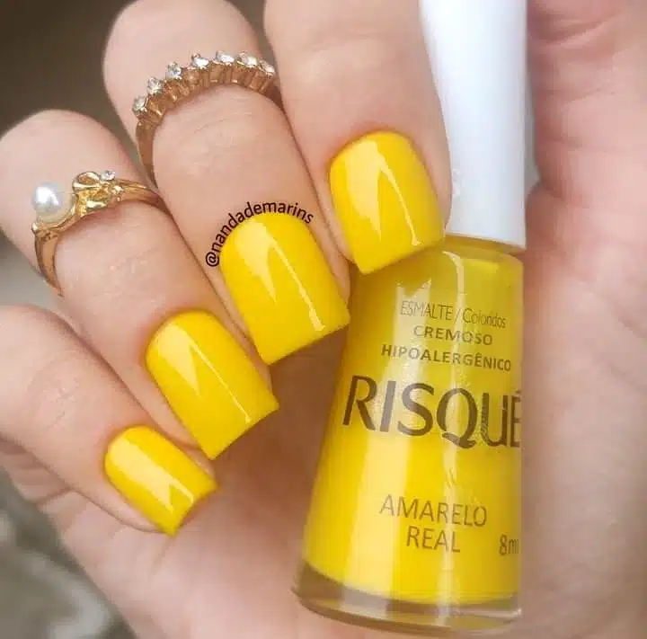 Unhas pintadas com esmalte amarelo mostarda em acabamento cremoso