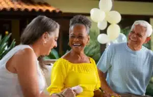 Pessoas maduras sorrindo e compartilhando momentos felizes juntos em um ambiente acolhedor.