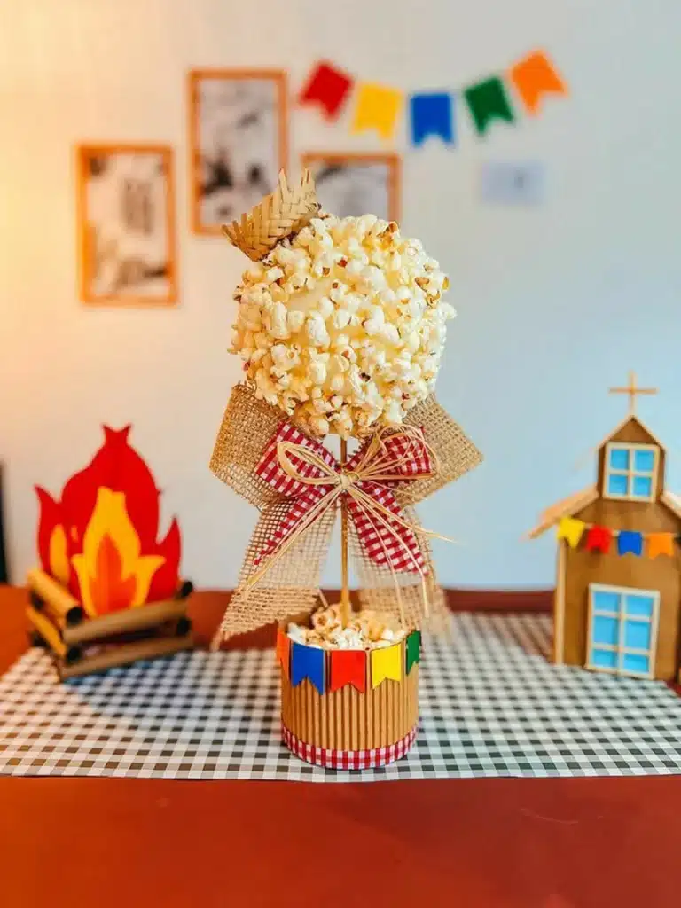 Arranjo decorativo de pipoca com laço de juta e bandeirinhas coloridas em base de papelão