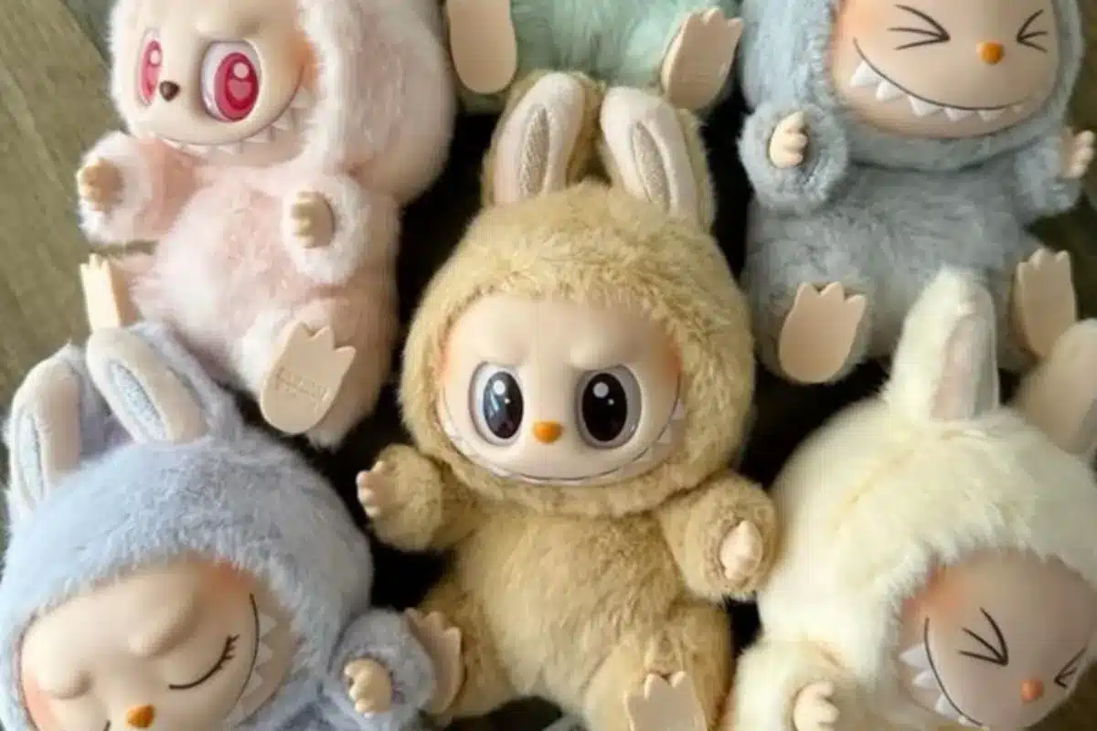 Bonecos fofos com roupinhas de pelúcia em diferentes cores e expressões variadas.