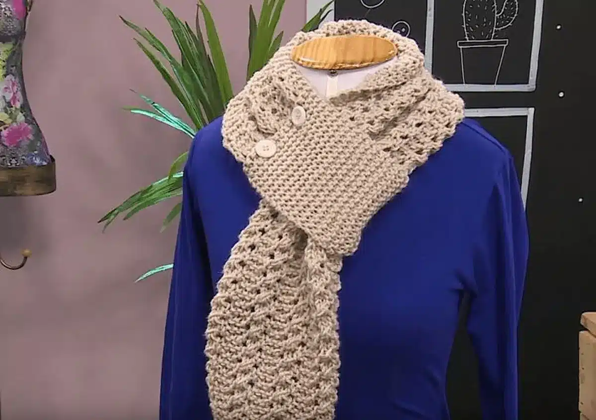 Cachecol de crochê bege com botões, estilo elegante para dias frios.