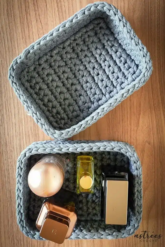 Cestinhas de crochê cinza usadas para organizar perfumes e acessórios