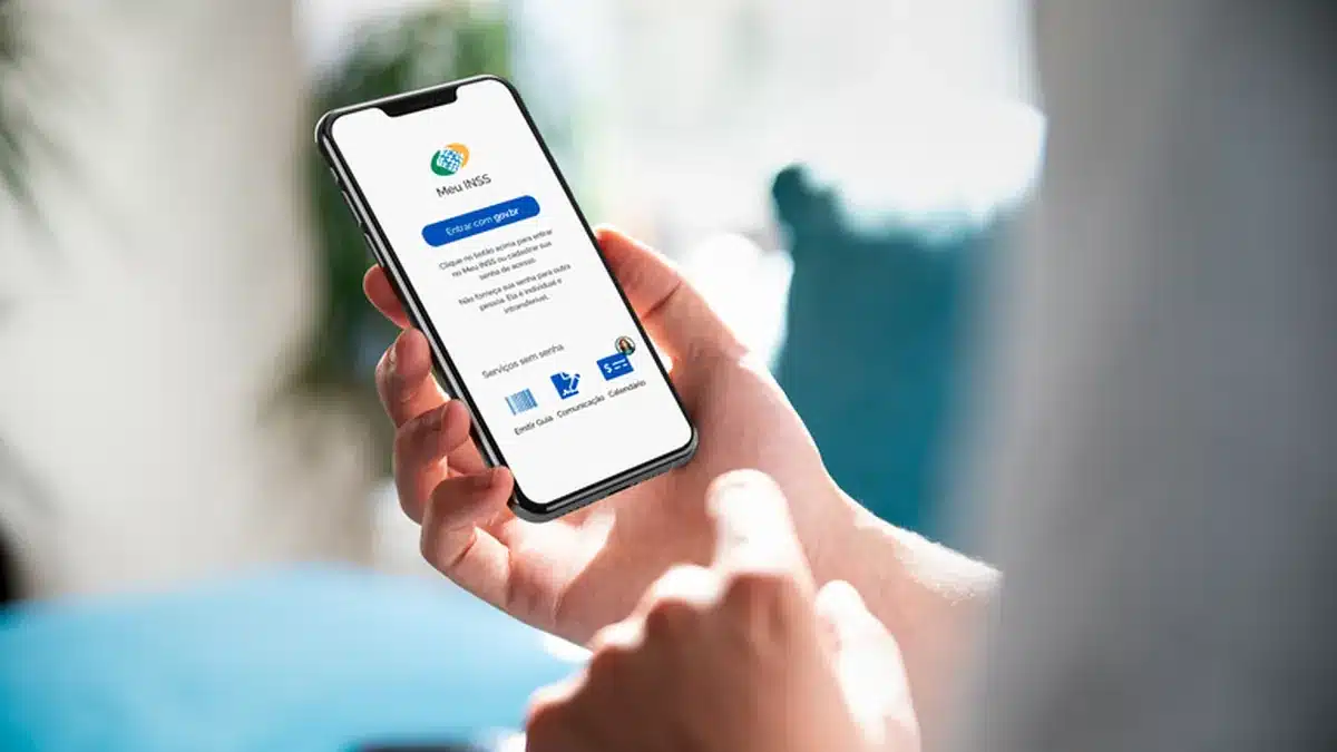 Pessoa acessando o aplicativo Meu INSS no celular para consultar benefícios previdenciários de forma online.