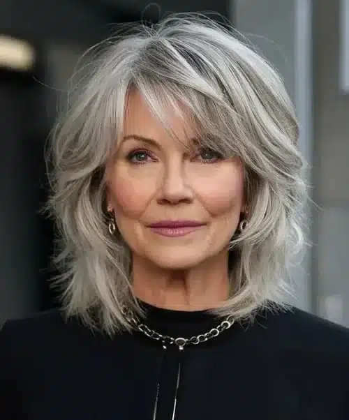 Mulher madura com cabelo médio em corte desgrenhado estilo shaggy, mostrando camadas e volume natural.