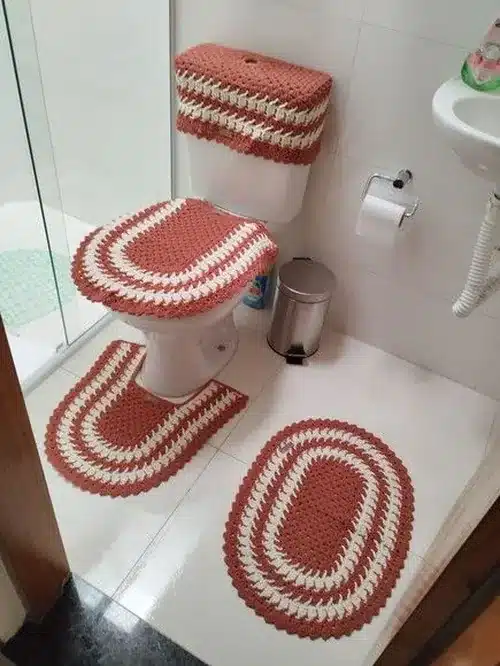 Conjunto de crochê sustentável em banheiro, com capa para vaso sanitário e tapetes