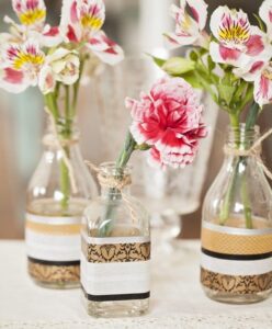 Vasos de plantas criativos feitos com garrafas de vidro recicladas, decorados com fitas adesivas.