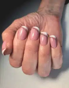 Imagem de unhas femininas com alongamento em gel, estilo francês, com detalhes delicados em tom rosa e branco.