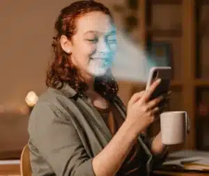 Mulher sorrindo enquanto desbloqueia o celular usando reconhecimento facial
