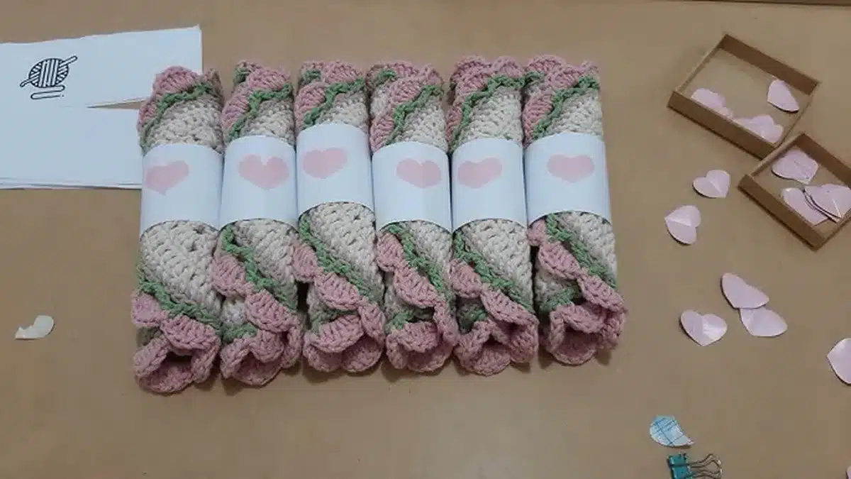 Sousplats de crochê enrolados com faixa decorativa, mostrando cuidado na embalagem para venda.