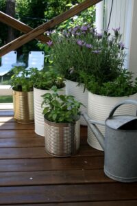 Vasos de plantas feitos com latas de alumínio recicladas, trazendo um toque sustentável à decoração de jardim.