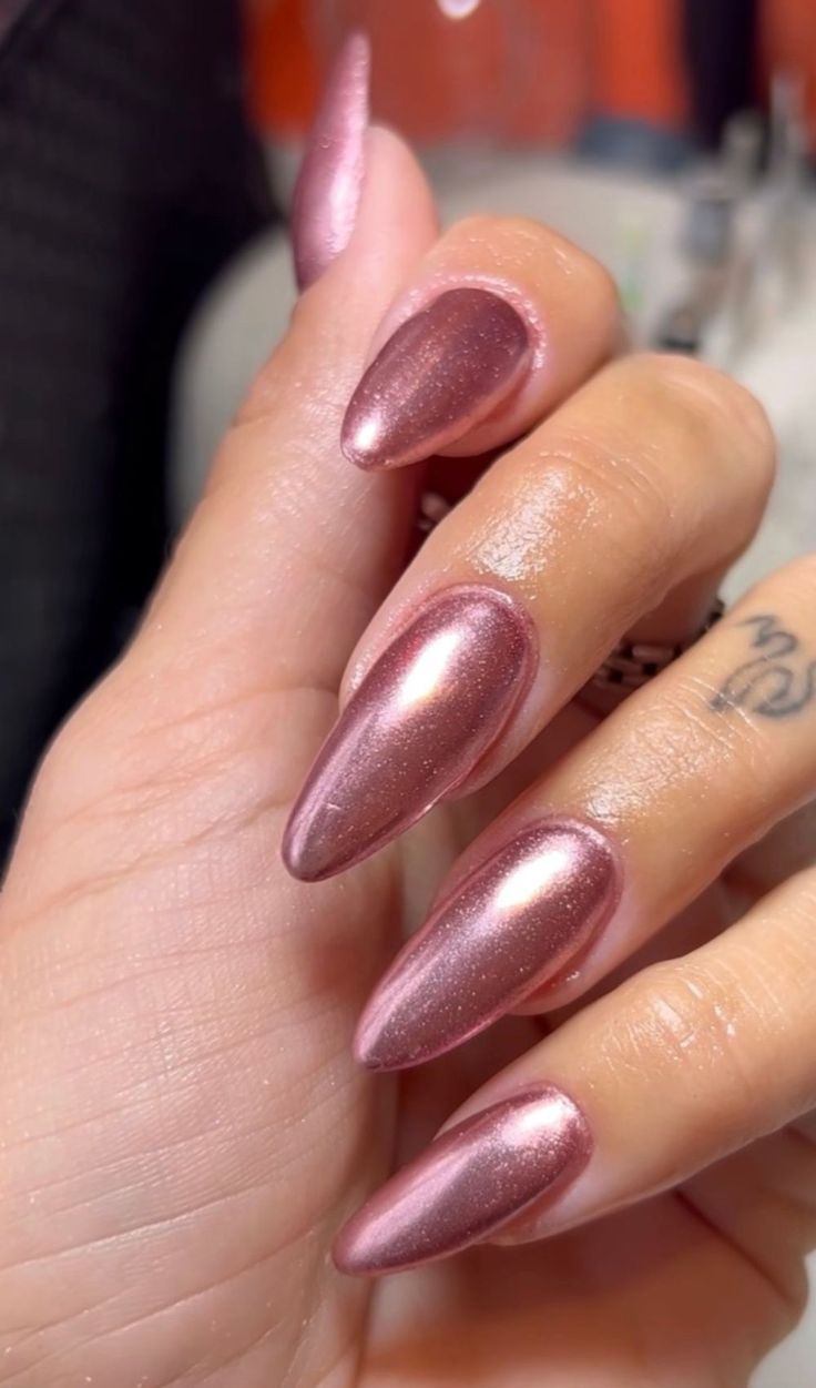 Unhas em gel metálicas na cor rosé, com acabamento brilhante e moderno, tendência para mulheres acima de 50 anos