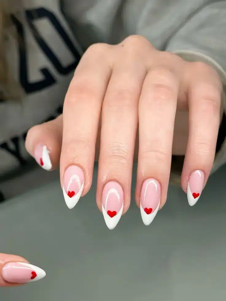  Unhas decoradas com francesinha branca e detalhe de corações vermelho