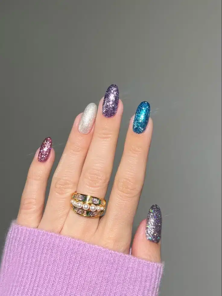 Unhas com esmalte glitter multicolorido em tons variados