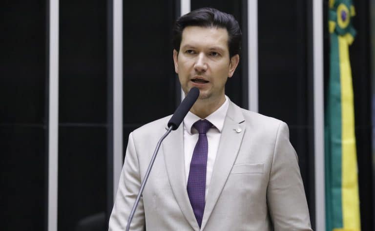 Deputado Gilson Marques falando ao microfone em sessão legislativa no Brasil.