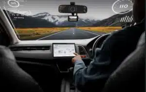 Painel interno de um carro autônomo em uma estrada aberta, mostrando tecnologia avançada de direção assistida.