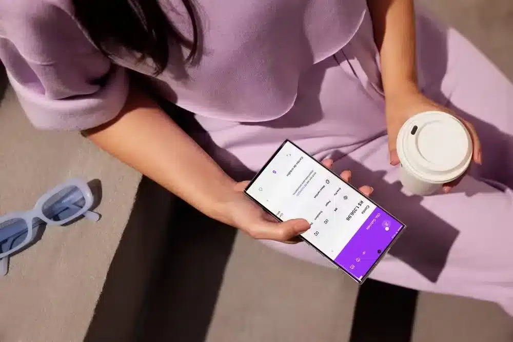 Pessoa utilizando o app do Nubank em um celular para fazer um pagamento com Pix por Aproximação, sem precisar de QR Code.