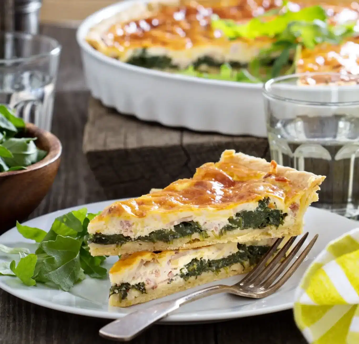 Fatias de quiche servidas com salada verde em prato rústico