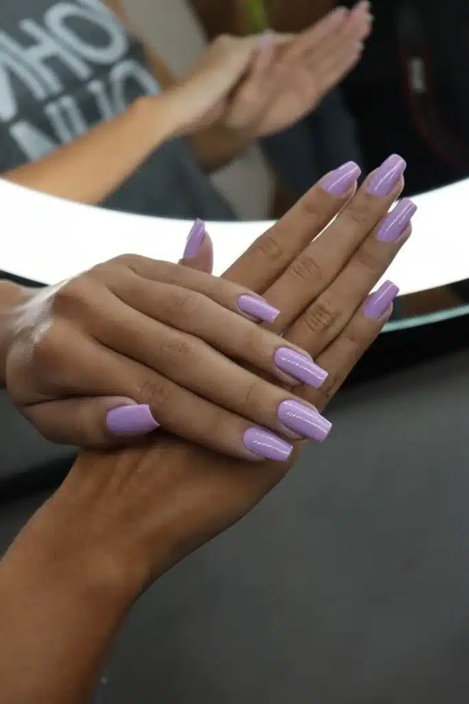 Unhas pintadas com esmalte roxo lavanda com acabamento brilhoso