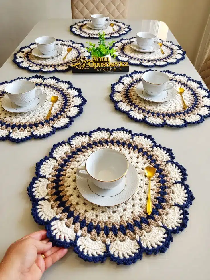 Sousplats de crochê circular em tons de bege e azul marinho decorando mesa de café