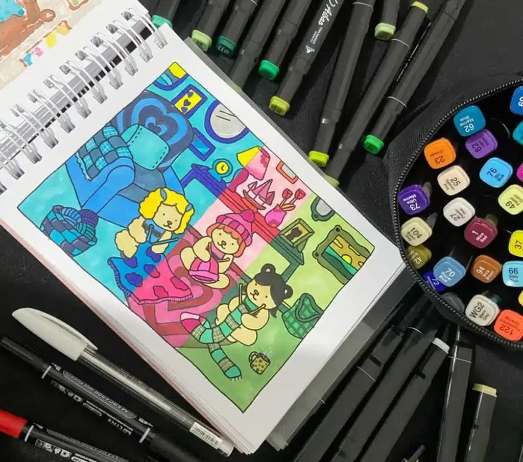 Desenho colorido de três personagens fofos tricotando em um ambiente aconchegante, com muitos marcadores artísticos ao redor.