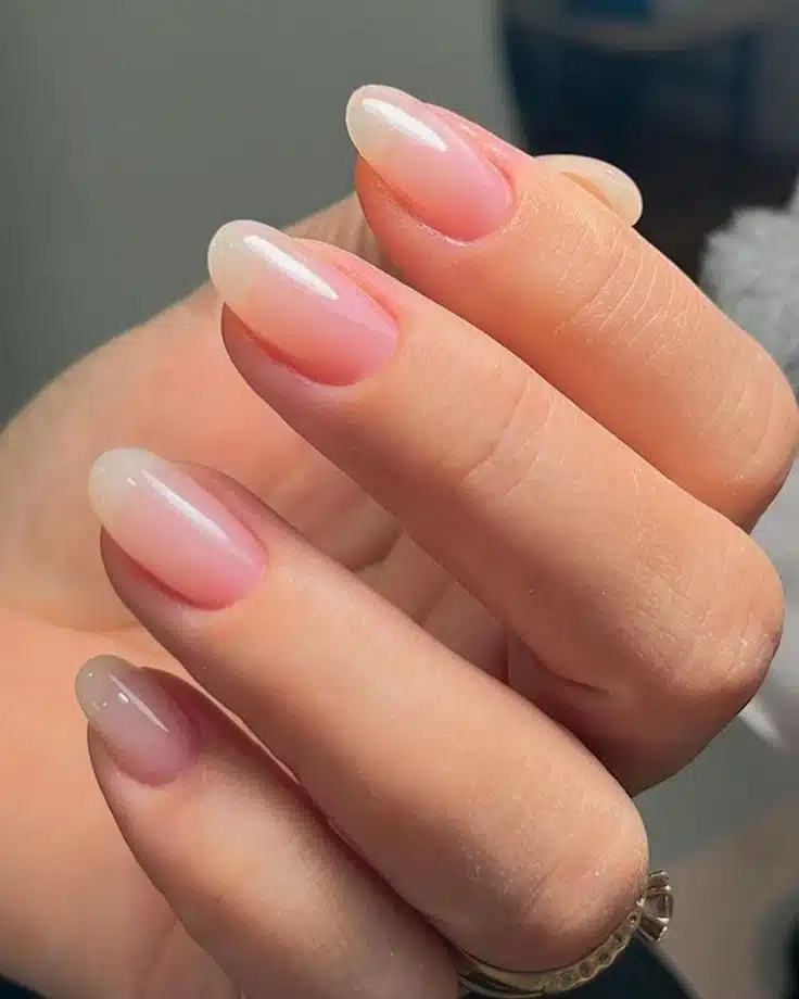Unhas de gel com acabamento natural e brilho intenso em formato oval.