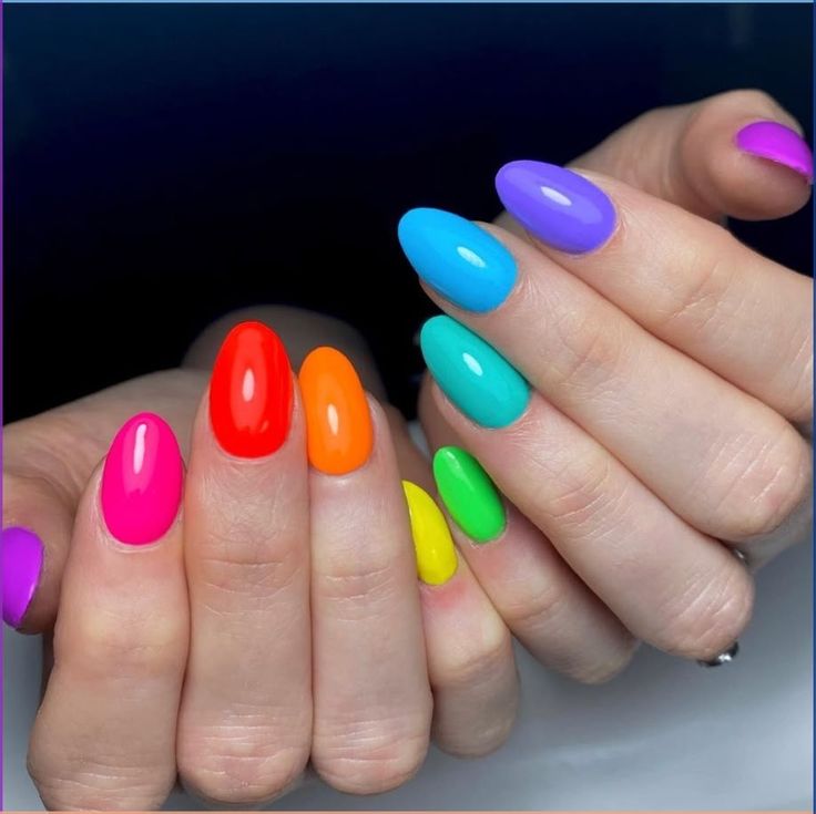 Unhas em gel decoradas com esmaltes em cores vibrantes como roxo, azul, pink, laranja e verde, tendência divertida para mulheres acima de 50 anos