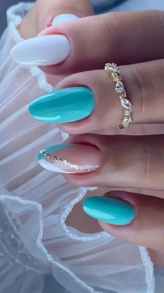 Unhas com esmalte azul turquesa e detalhes em branco e dourado