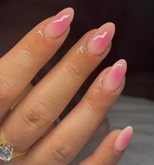Unhas minimalistas em tons de rosa com detalhe de brilho em formato de aura.