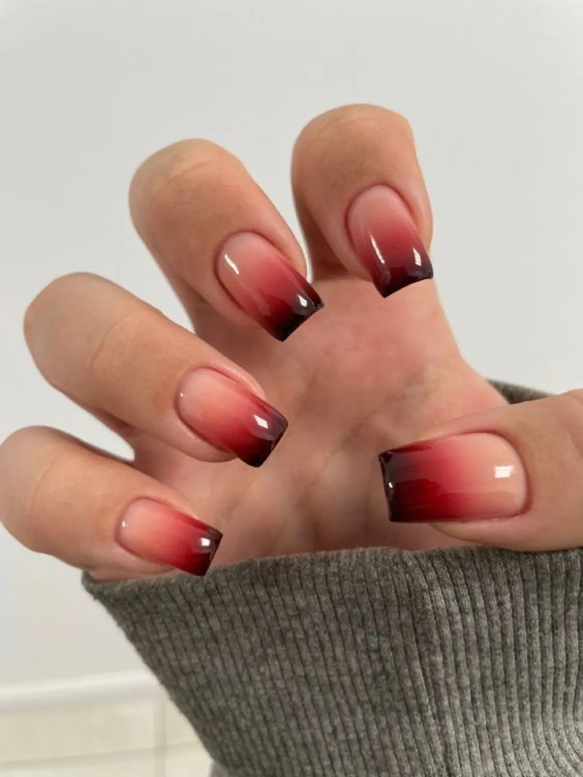Unhas com efeito meia de seda em degradê vermelho esfumado