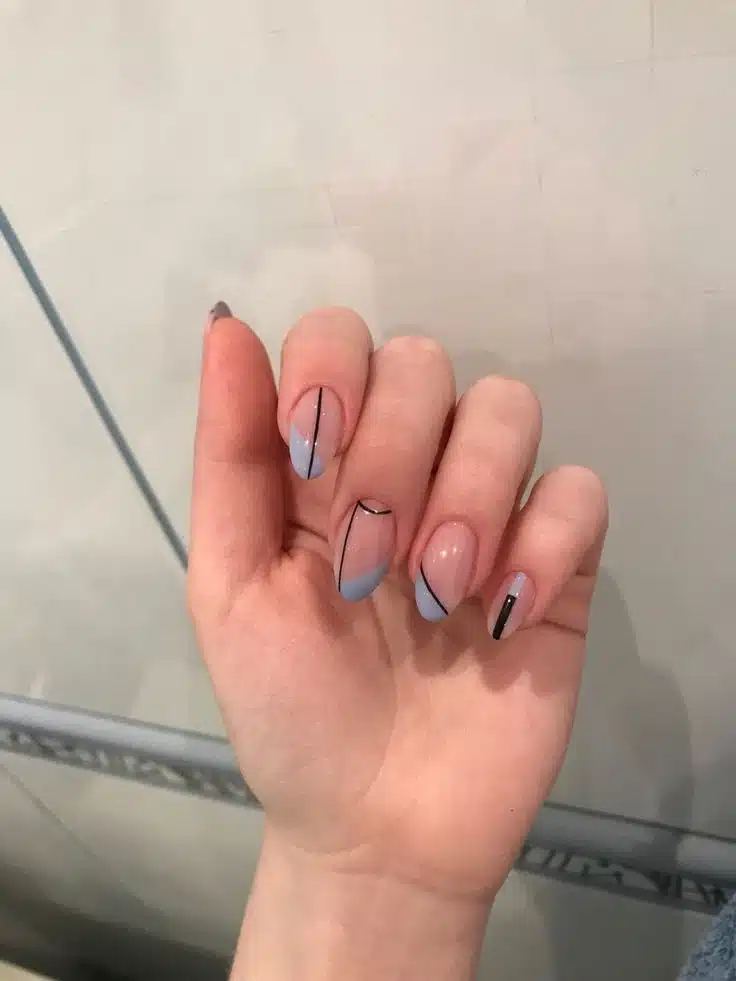 Unhas redondas com design geométrico em azul claro e linhas pretas finas
