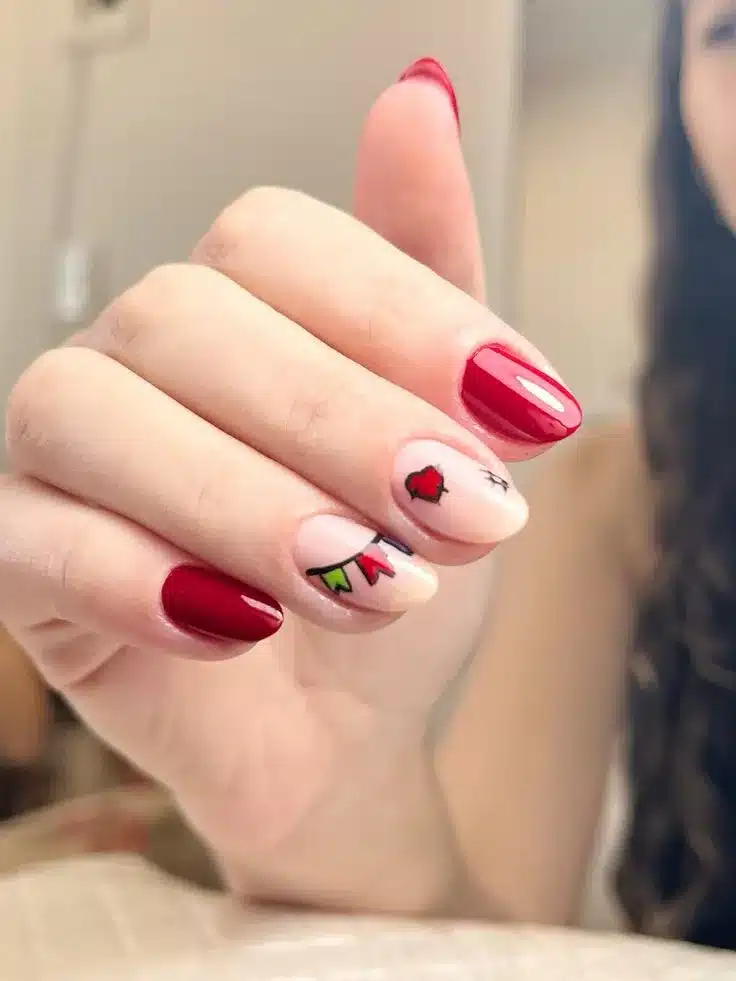 Unhas com esmalte vermelho vibrante e desenhos coloridos de bandeirinhas e coração