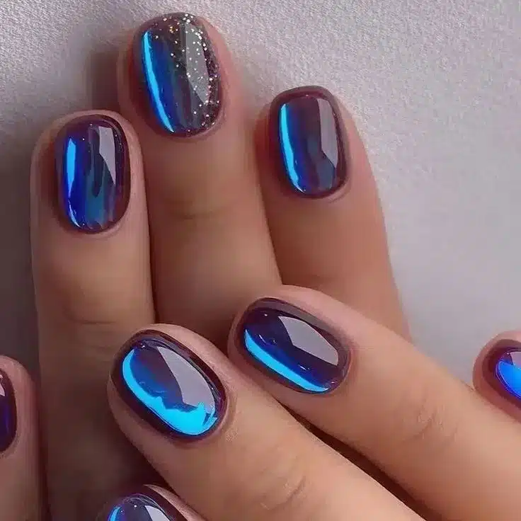 Unhas com efeito magnético olho de gato para Outono 2025, com tom roxo e brilho azul.