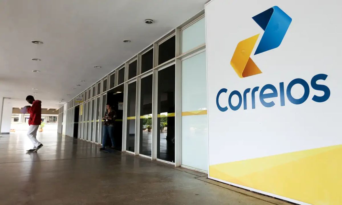 Fachada com logo dos Correios e pessoas circulando