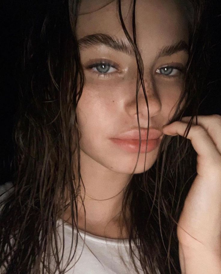 Mulher com cabelo molhado e maquiagem natural, destacando o visual de brilho e frescor, tendência de cabelo molhado de 2025.