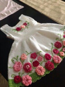 Vestido de crochê infantil branco com flores em tons de rosa e bordado verde