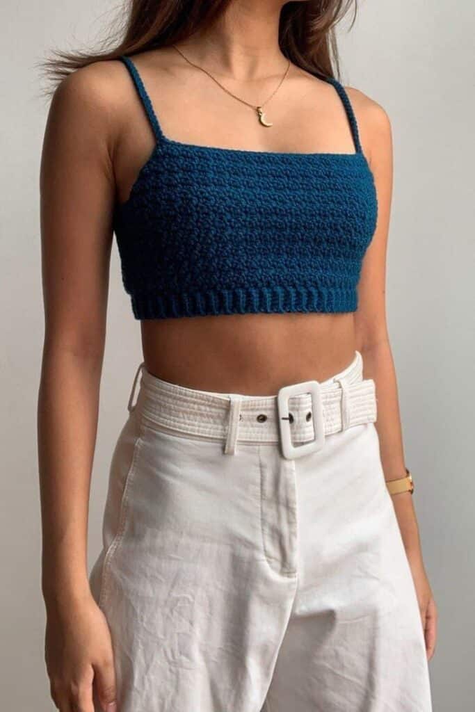 Cropped de crochê azul marinho com alças finas usado com calça branca de cintura altCropped de crochê azul marinho com alças finas usado com calça branca de cintura alta