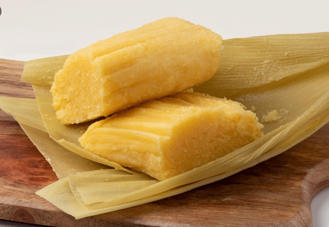 Pamonha típica de festa junina, envolta em palha de milho.