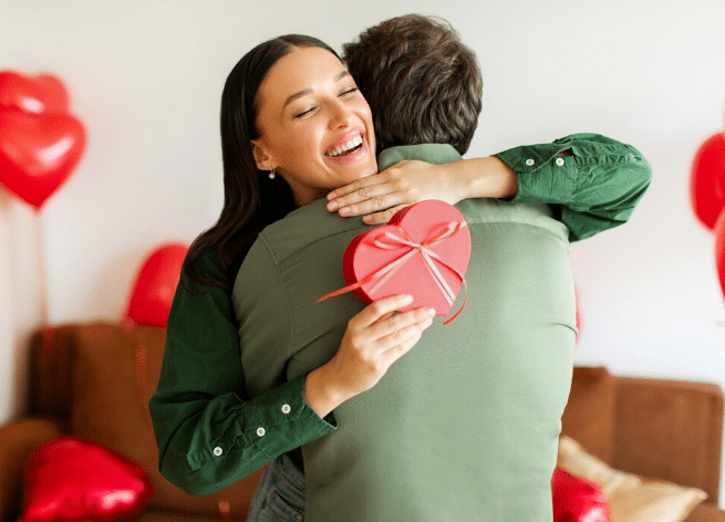 Casal trocando presente em formato de coração durante comemoração do Dia dos Namorados