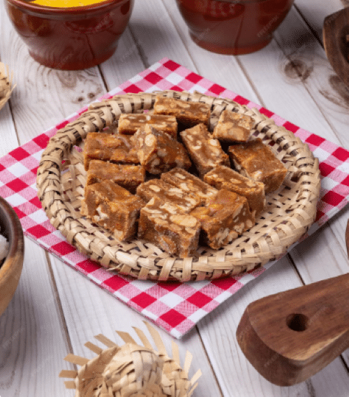 Docinhos de pé de moça em prato de palha com decoração típica de festa junina