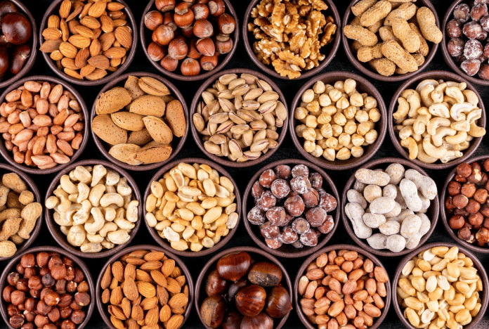 Diversos tipos de nozes e sementes, como amêndoas, castanhas e pistaches, ricos em nutrientes que fortalecem cabelos e unhas.