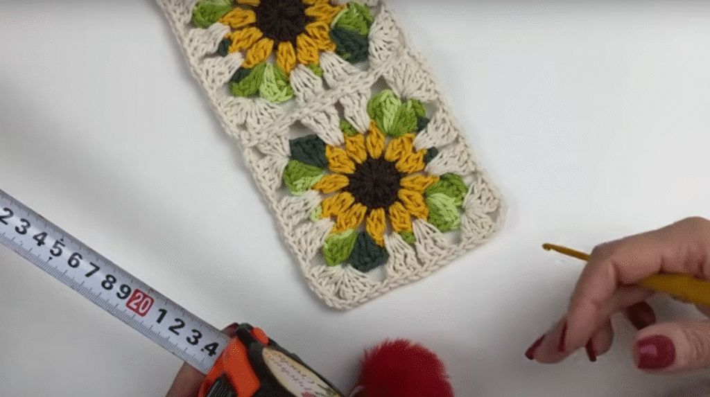 Detalhe da montagem de square de crochê com girassol rasteiro para passadeira ou caminho de mesa.