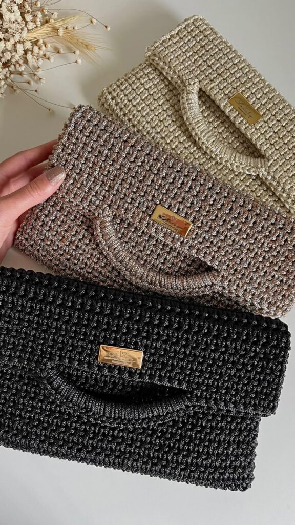 Três bolsas clutch de crochê com acabamento brilhante