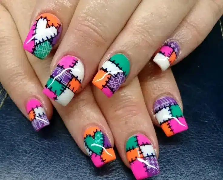 Estampa de retalhos em unhas: O charme do patchwork Unhas com estampa de retalhos no estilo patchwork, combinando cores vibrantes e costuras decorativas, perfeitas para um visual criativo e festivo.