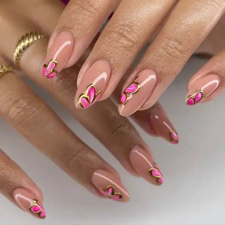 Unhas minimalistas com flores 3D em rosa e detalhes dourados.